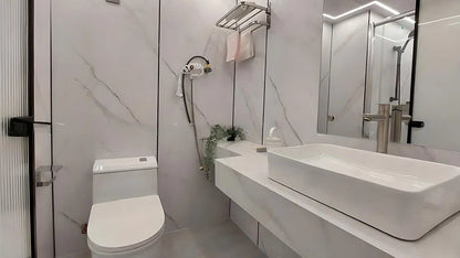 Modern bathroom with white toilet, sink, and shower area in AP-2 Balanced Apple Cabin