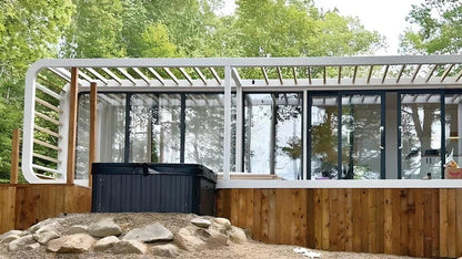Modern outdoor AP-3 Apple Cabin Extended with a wooden base and glass walls, surrounded by trees.