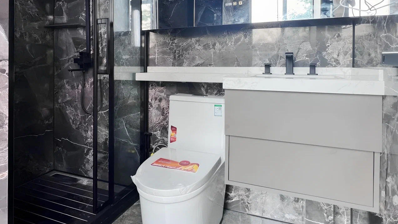 Apple Cabin Bathroom with gray tiles, toilet, and vanity mirror.