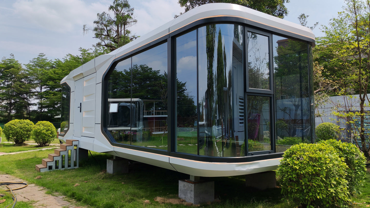 Modern modular sx-3 vista space capsule hotel pod with large glass windows in a green outdoor setting