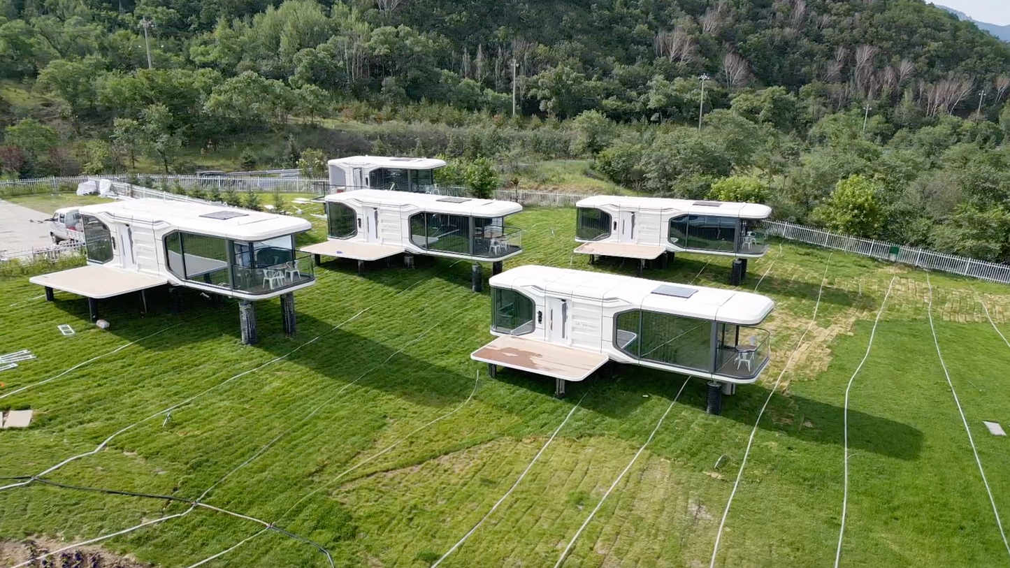 Modern modular sx-3 vista space capsules on pile supports arranged in a field with trees in the background