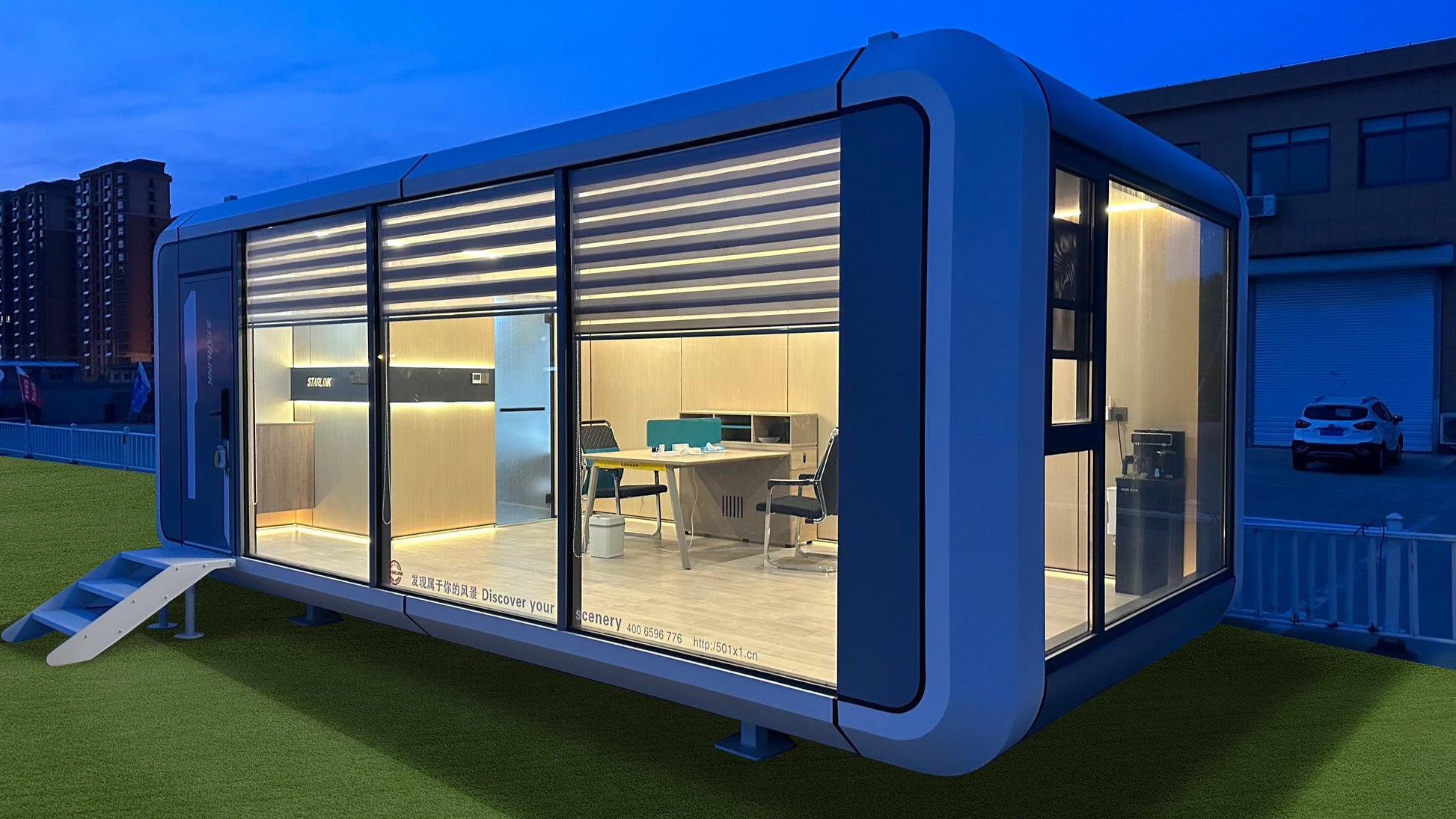 Modular cabin exterior at night with panoramic glass walls and interior lighting, AP-2 Balanced Apple Cabin prefab unit