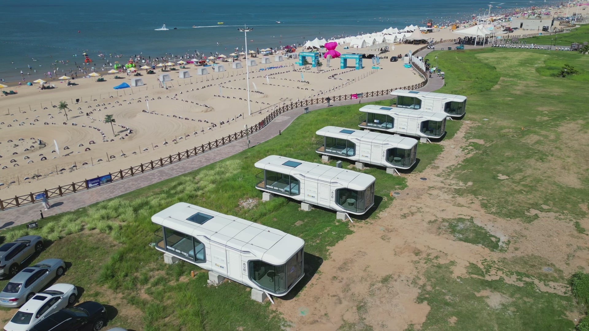 Load video: Aerial footage showing multiple prefabricated modular living units arranged in a large-scale coastal development.